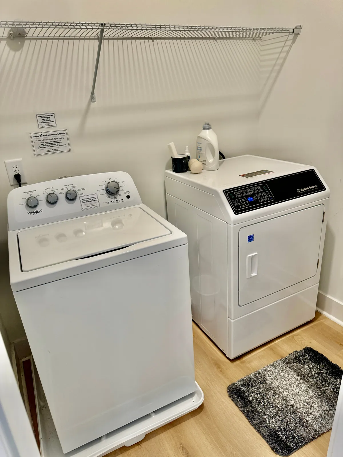 A practical laundry space with a washing machine, dryer, shelving, and organized laundry supplies. The setting is clean and efficient, reflecting the convenience described in the section.