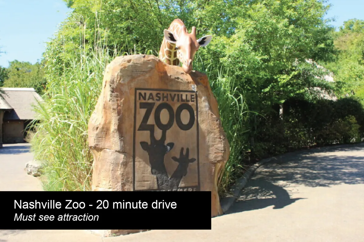 An exterior shot of the Nashville Zoo entrance, featuring a welcoming rock sign, giraffe sculpture, and lush landscaping. The scene buzzes with a sense of adventure and is clearly geared toward family outings and exploration.